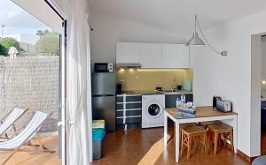 una cucina con tavolo e piano cottura forno superiore di Apartamento Binibeca Nou Cami de Cavalls a Binibeca