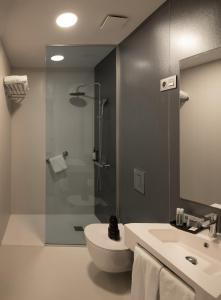 a bathroom with a shower and a toilet and a sink at RK Farallón Canteras in Las Palmas de Gran Canaria