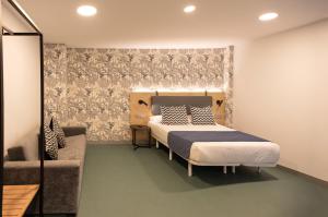 een slaapkamer met een bed en een bank bij RK Farallón Canteras in Las Palmas de Gran Canaria