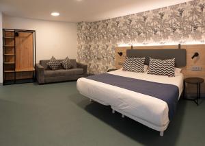 a bedroom with a large bed and a couch at RK Farallón Canteras in Las Palmas de Gran Canaria