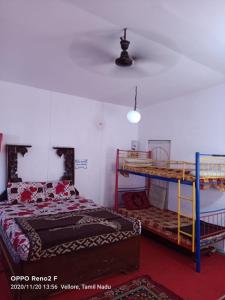 a bedroom with two bunk beds and a ceiling at John home stay in Yelagiri