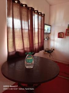 a table with a vase sitting on top of it at John home stay in Yelagiri