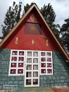 a small house with a red roof and windows at John home stay in Yelagiri