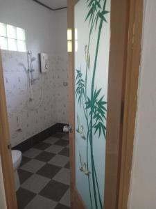 a bathroom with a shower with palm trees on the wall at Chom Suan Farmstay in Ko Kood