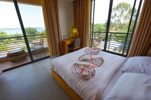 Una habitación de hotel con una cama con dos decoraciones. en K Hotels Entebbe en Entebbe