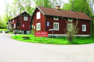 a red house with a sign in front of it at Sergel B&B Lindshammar in Lindshammar