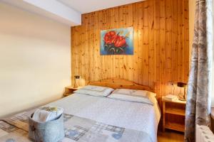 1 dormitorio con 1 cama y una pintura en la pared en Appartamento Federia en Livigno