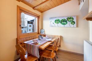 uma sala de jantar com uma mesa com cadeiras e uma janela em Appartamento Federia em Livigno