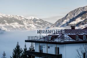 a building with a sign on top of it with mountains at Design Hotel Miramonte in Bad Gastein