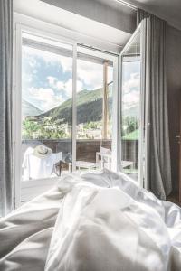 a bedroom with a bed and a large window at Design Hotel Miramonte in Bad Gastein