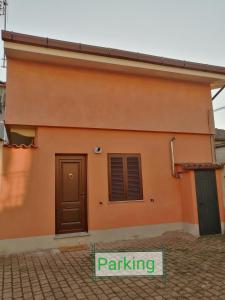 a building with a door and a sign that reads parking at La Casetta in San Maurizio Canavese