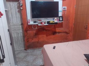 a living room with a television on a wall at Casa Mobiliada in Manaus