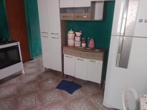マナウスにあるCasa Mobiliadaのタイルフロアのキッチン(白い冷蔵庫付)