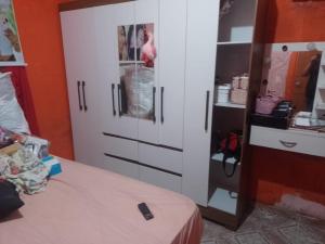 1 dormitorio con 1 cama y armario blanco en Casa Mobiliada, en Manaus