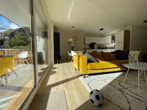 a living room with a yellow couch and a table at Holland 7 im Torrentblick brandnew family appartment in Leukerbad