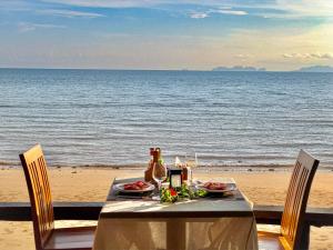 einen Tisch mit Speisen und Getränken am Strand in der Unterkunft Koh Jum Ocean Beach Resort in Ko Jum