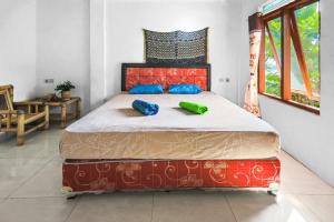 1 cama con 2 almohadas en una habitación en Palulu Garden Homestay en Labuan Bajo