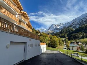 a building with a garage and mountains in the background at Holland 7 im Torrentblick brandnew family appartment in Leukerbad