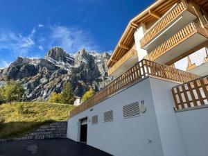 a white building with a mountain in the background at Holland 7 im Torrentblick brandnew family appartment in Leukerbad