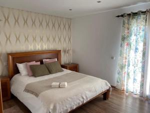 una camera da letto con un letto con un fiocco bianco di Casa De Campo Natureza a Porto de Mós