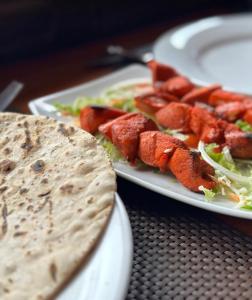 una mesa con dos platos de comida y una tortilla en Queenswood Cottage, en Nuwara Eliya