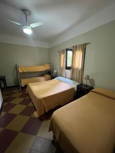 ein Hotelzimmer mit zwei Betten und einem Schachbrettboden in der Unterkunft Posada del Bosque in Tanti