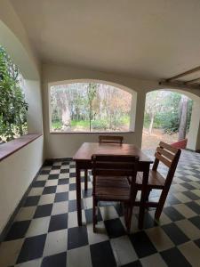 ein Esszimmer mit Tisch und Stühlen und einem Fenster in der Unterkunft Posada del Bosque in Tanti