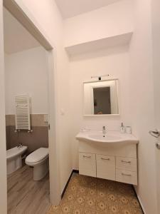 a bathroom with a sink and a toilet and a mirror at Casa Betti in Rapallo