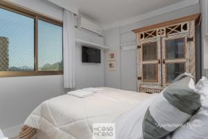 Habitación blanca con cama y ventana en TOP 3 QUARTOS com ESTACIONAMENTO em Condominio com PORTARIA 24h, PISCINA, Sauna e Parquinho Infantil - Apartamento com Ar Condicionado, SmarTV, Wi-Fi 120 mbps e Cozinha Completa, en Río de Janeiro