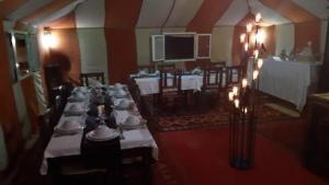 uma grande sala com mesas e cadeiras com luzes em sunset luxury camp em Merzouga