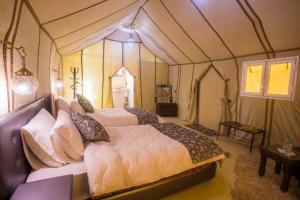 um quarto com 2 camas numa tenda em sunset luxury camp em Merzouga