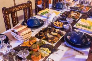 uma longa mesa cheia de diferentes tipos de alimentos em sunset luxury camp em Merzouga