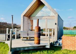 a small house with a pipe on a deck at Lushna 10 Classic Suite at Lee Wick Farm Cottages & Glamping in Clacton-on-Sea
