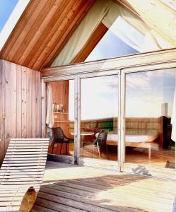 a conservatory with a large window and a table at Lushna 11 Lux Suite at Lee Wick Farm Cottages & Glamping in Clacton-on-Sea