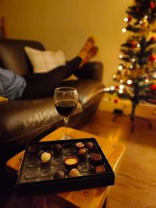 a glass of wine and a tray of donuts and a christmas tree at Sandpiper Cottage in Alnham