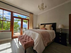 a bedroom with a large bed and a large window at Valley View Eco Country Estate - Paradise in the Winelands in Villiersdorp