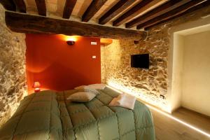 a bedroom with a bed in a stone wall at Le Dimore dei Ritaldi in Castel Ritaldi