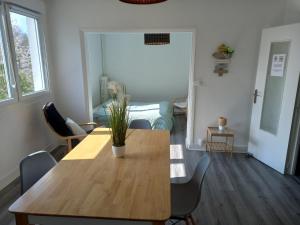 einen Tisch und Stühle in einem Wohnzimmer mit einer Person in der Unterkunft L'escale champenoise , wifi garage parking privè gratuit in Châlons-en-Champagne