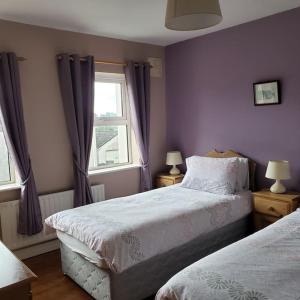 um quarto roxo com 2 camas e uma janela em Modern house, Westport town em Westport