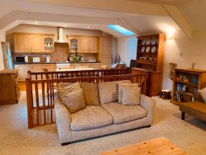 a living room with a couch and a kitchen at 4 Swallowholm Cottage in Langthwaite
