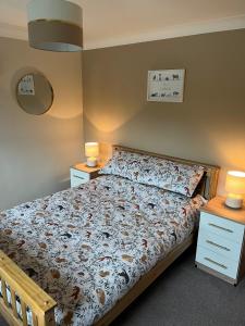 a bed in a bedroom with two night stands and two lamps at 4 Swallowholm Cottage in Langthwaite