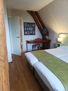 een slaapkamer met een bed, een bureau en een tafel bij Hôtel La Reconce in Poisson