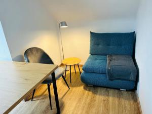 uma sala de estar com uma cadeira azul e uma mesa em Apartment mit Blick aufs Schloss 