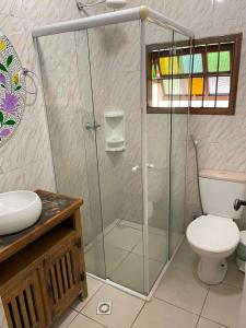a bathroom with a shower with a toilet and a sink at Pousada Bonns Ventos in Ilhabela