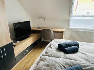um quarto com uma cama e uma secretária com uma televisão em Apartment mit Blick aufs Schloss 