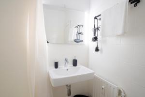 Baño blanco con lavabo y espejo en HOMEFY STUDIO HEAVEN - SELF CHECK-in - PARKING LOT - ELEVATOR, en Essen