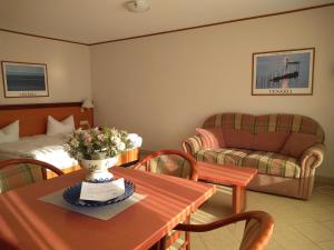 a living room with a table and a bed and a couch at Hotel Esplanade & Aparthotel Rialto in Binz