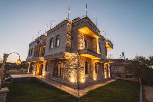 a large house with lights on the front of it at Leda Stone House in Nevsehir
