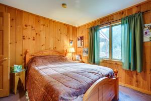 威爾明頓的住宿－Secluded Wilmington Retreat about 4 Mi to Mount Snow，一间卧室配有一张带木墙和窗户的床。