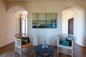 a living room with two chairs and a table at Hôtel Case Latine in Lama